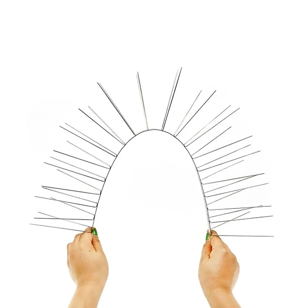 Hands bending flexible stainless steel bird spikes into an arc shape for pest control.