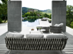 Lido 3-seater outdoor sofa with a modern woven design, set in a contemporary outdoor dining space.