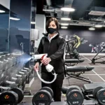 A person using the CLE031-3 Vycel Backpack Sprayer in a gym environment for effective disinfection.