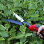 Darlac Swivel Shears trimming foliage with adjustable blades, showcasing precise cuts and ergonomic handling for shrubs and hedges.