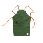 We The Wild gardening apron in green, with pockets and loops for tools, designed for durable and convenient gardening.