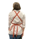 Back view of We The Wild gardening apron with cross-back adjustable straps in orange, worn by a person.